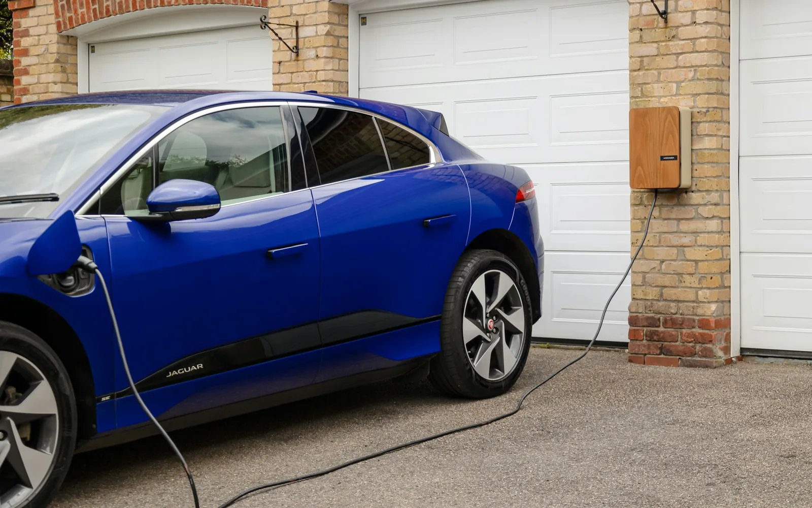 Coche eléctrico conectado a un punto de recarga doméstico